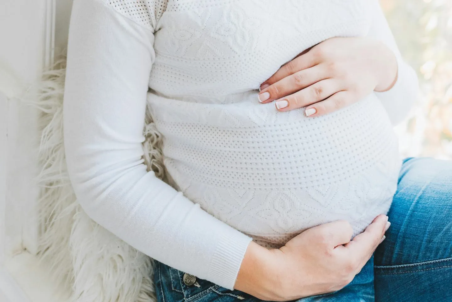 A woman holding her pregnancy bump