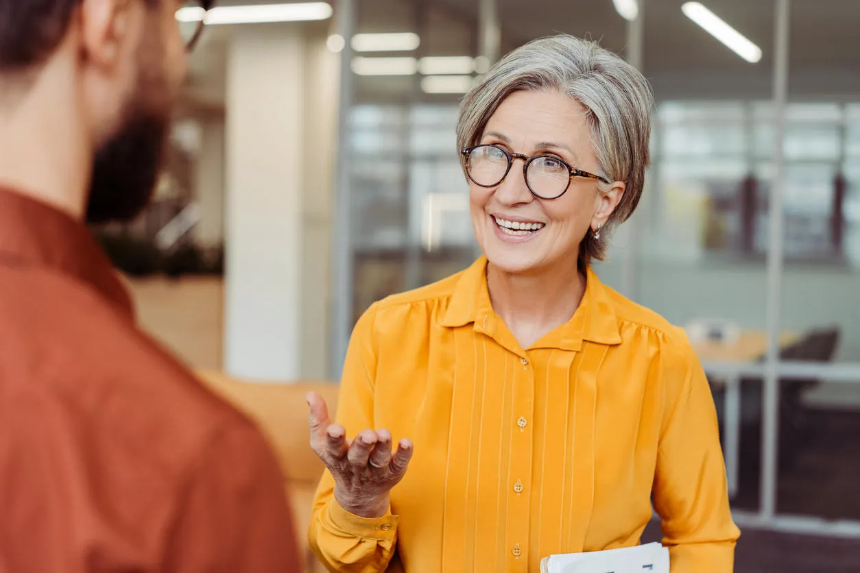 A smiling woman explaining something to a man.