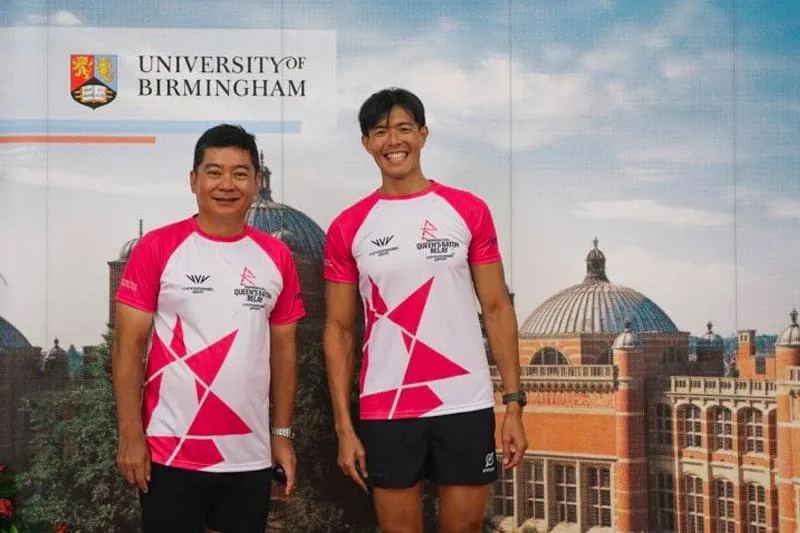 Baton bearer Bernard Tan and Alvin Ho posing against a University of Birmingham Aston Webb backdrop
